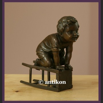Figurka z brązu słodki malec śliczny brąz chłopiec na stołku sygnowana rzeźba