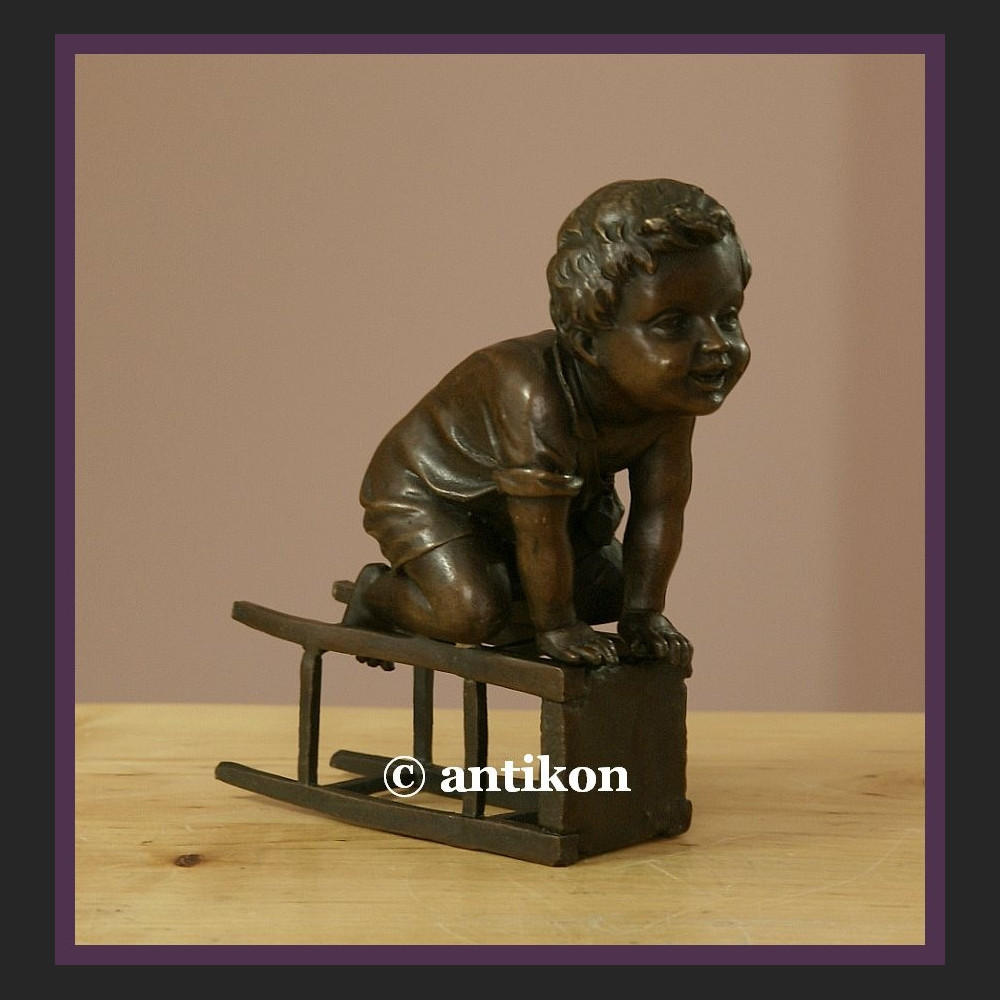 Figurka z brązu słodki malec śliczny brąz chłopiec na stołku sygnowana rzeźba