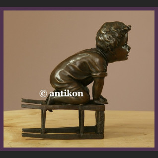 Figurka z brązu słodki malec śliczny brąz chłopiec na stołku sygnowana rzeźba