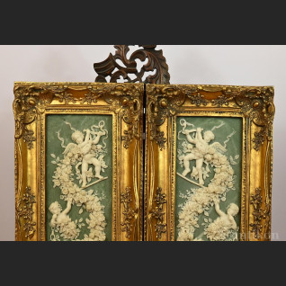 Reliefy z aniołkami w złotej ramie 